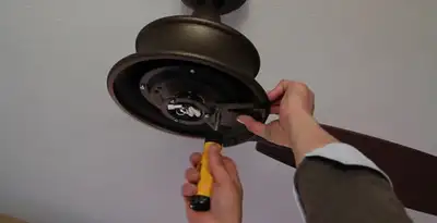 Electrician installing ceiling fan mounting bracket and fixture in Sarasota, FL