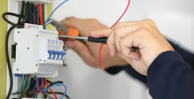 Electrician installing and adjusting circuit breakers in an electrical panel in Sarasota, FL
