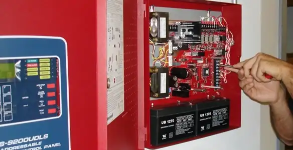 fire alarm installation service showing technician configuring fire alarm control panel in Sarasota, FL