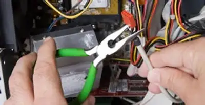 Licensed electrical contractor performing electrical repair with tools in Nokomis, FL
