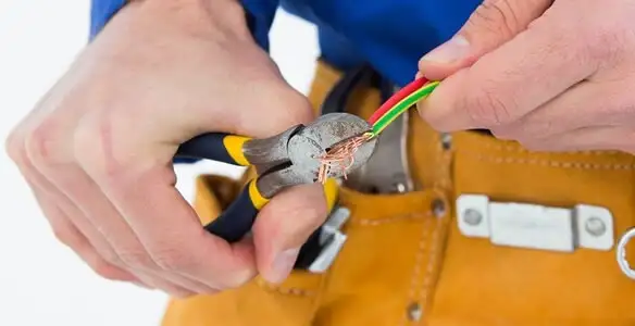licensed electrician securing electrical wiring with professional tools during service work in Sarasota, FL