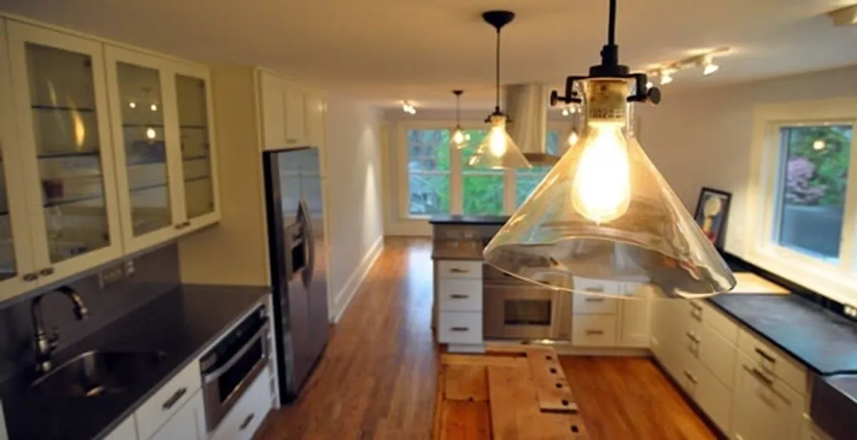 Residential electrician installing modern indoor light fixture in a home in Sarasota, FL