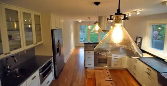 Residential electrician installing modern indoor light fixture in a home in Sarasota, FL